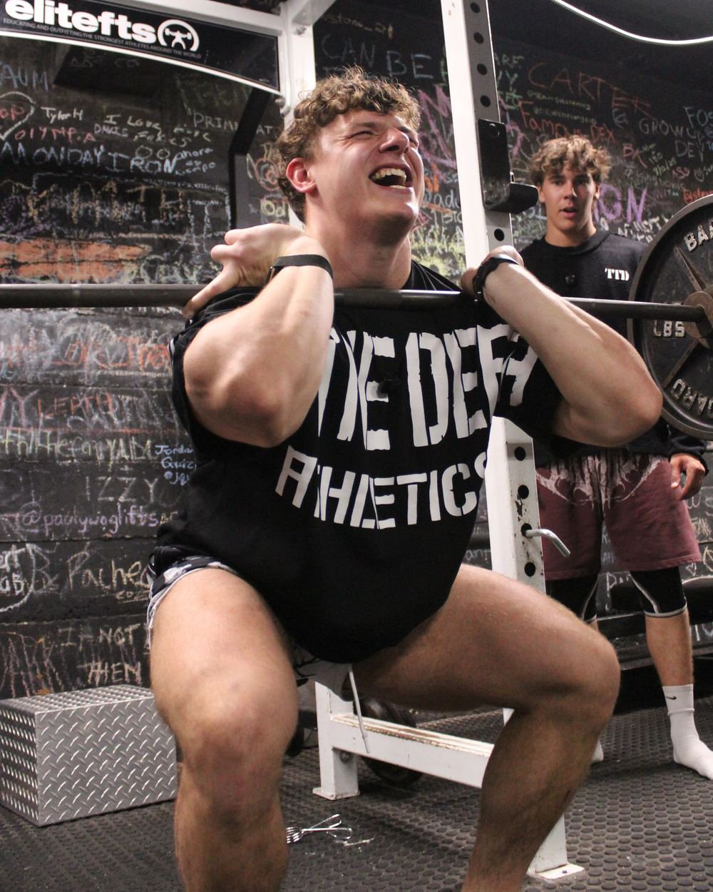 CJ Fazio at the bottom of a heavy front squat, elbows up and bar on his delts